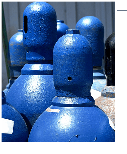 A group of blue gas cylinders sitting next to each other.