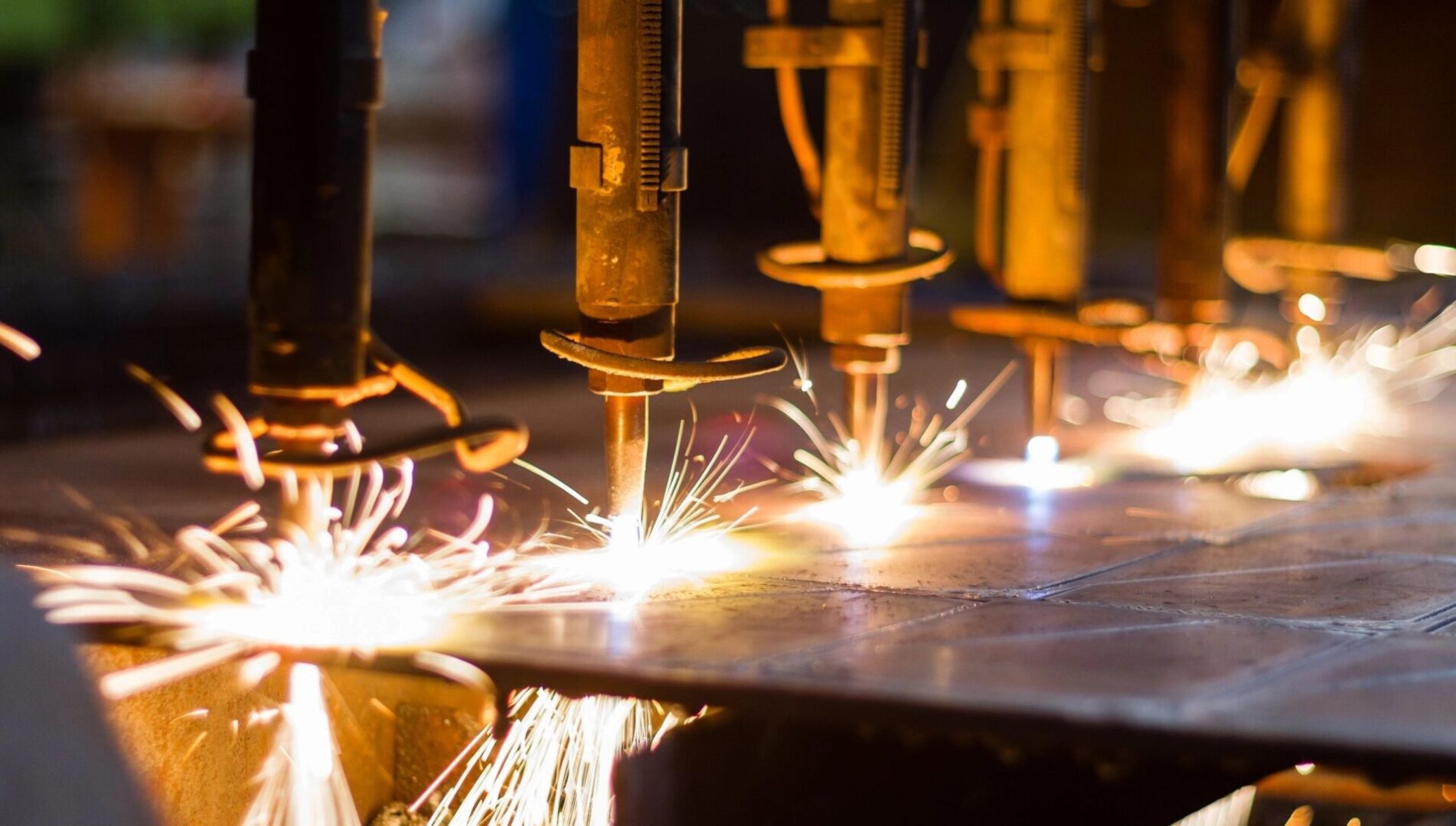 A group of people welding metal with sparks flying.